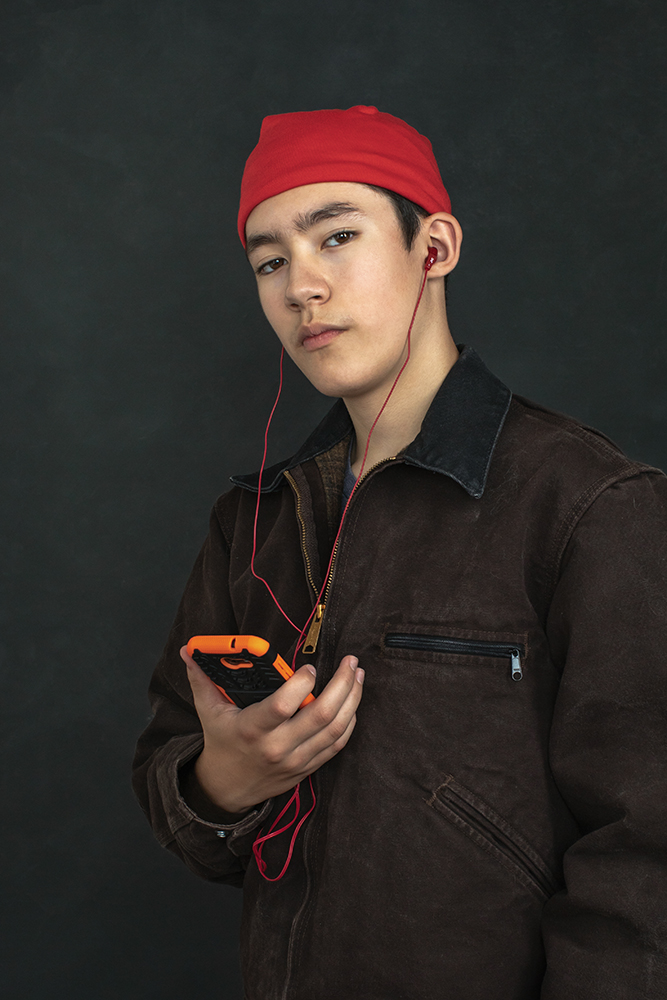 Portrait of a Young Man With Phone and Earbuds