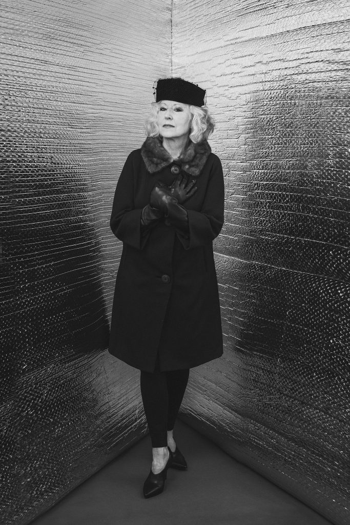 Modern "Corner Portrait" of Hanna wearing a 1960s coat, hat and gloves