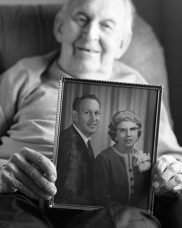 Black & White Portrait of Elderly Man Holding Wedding Photo