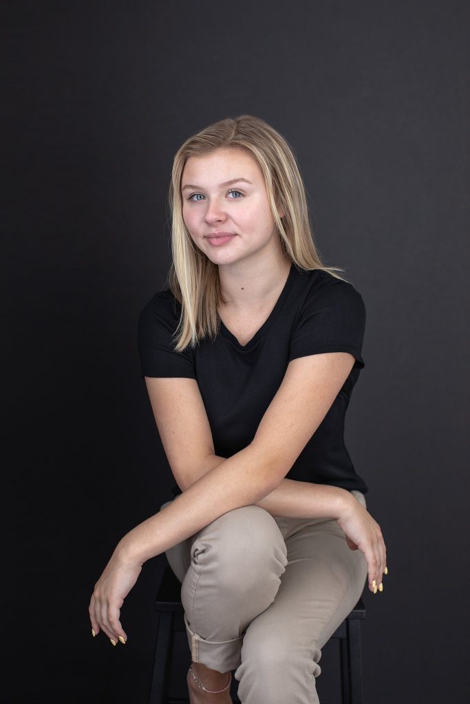 Portrait of a seated actor and singer on a black background