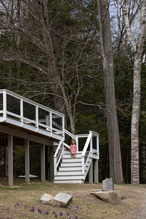 A young girl sits on her front steps