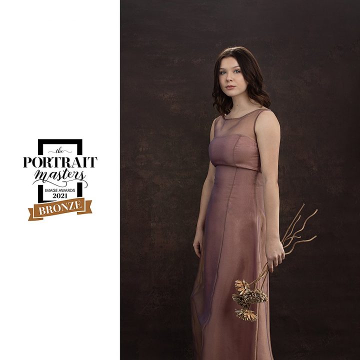 Senior photo of girl in a pink gown, with flowers