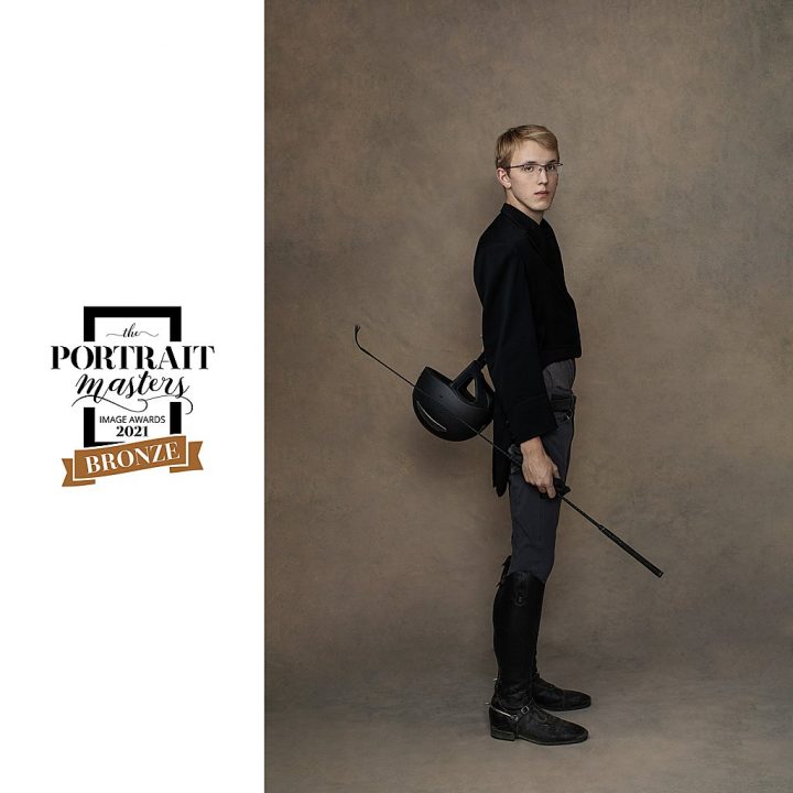 Portrait of teenage boy wearing equestrian gear