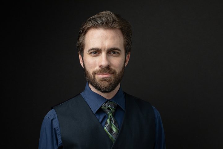 Men's headshot vest tie black background