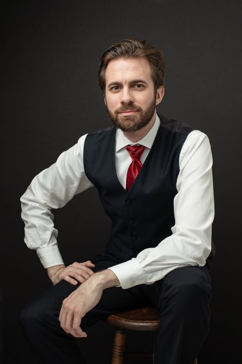 Men's portrait with vest and tie, black background