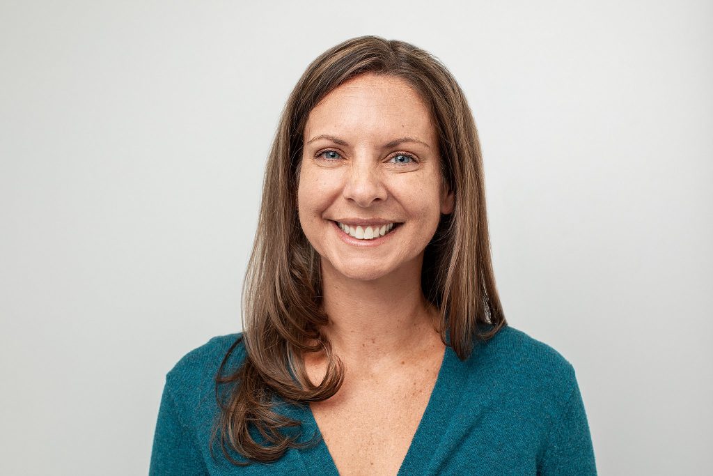 A professional headshot with a light background for an entrepreneur