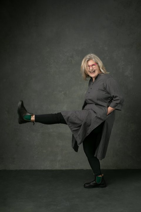 Evelyn kicking and laughing, with hair blowing across her face