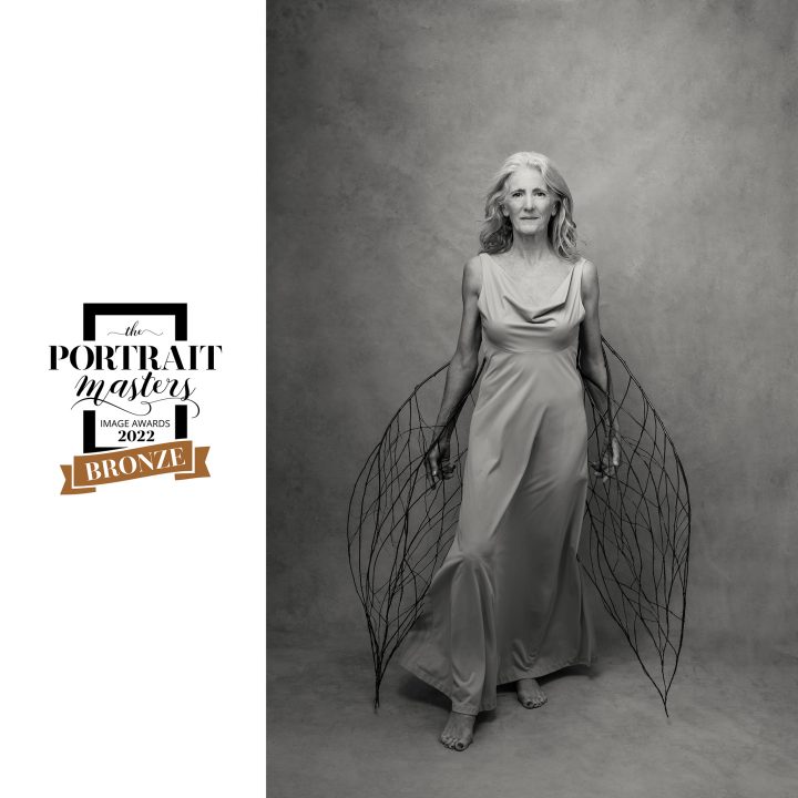 "Phoenix" - a black and white portrait off a woman holding twig "wings"