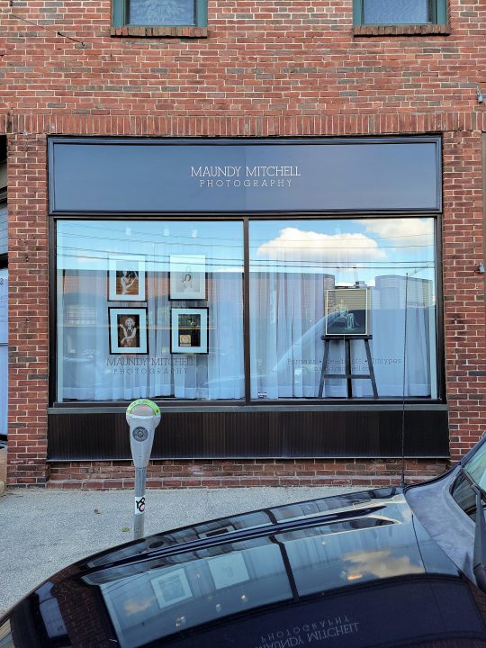 A photo of Maundy Mitchell's street-level studio, with the windows and new sign