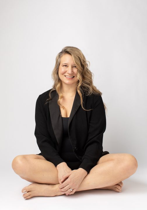 Amanda sitting cross-legged, smiling