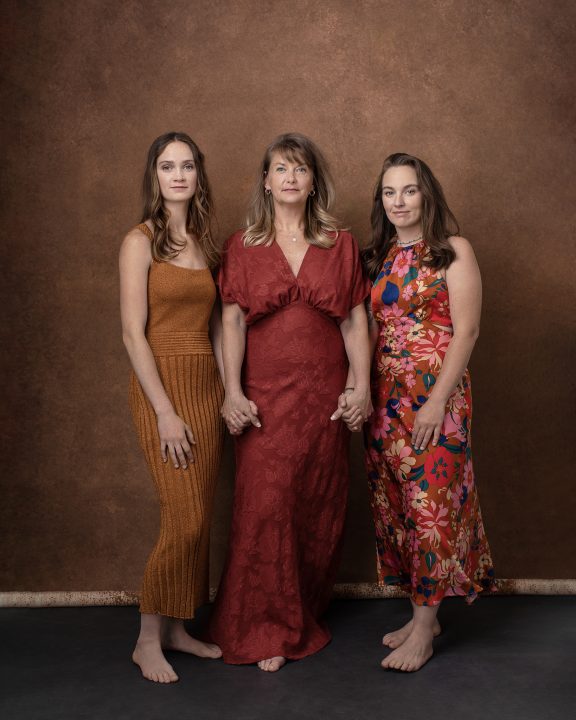 A mother-daughters portrait with orange tones