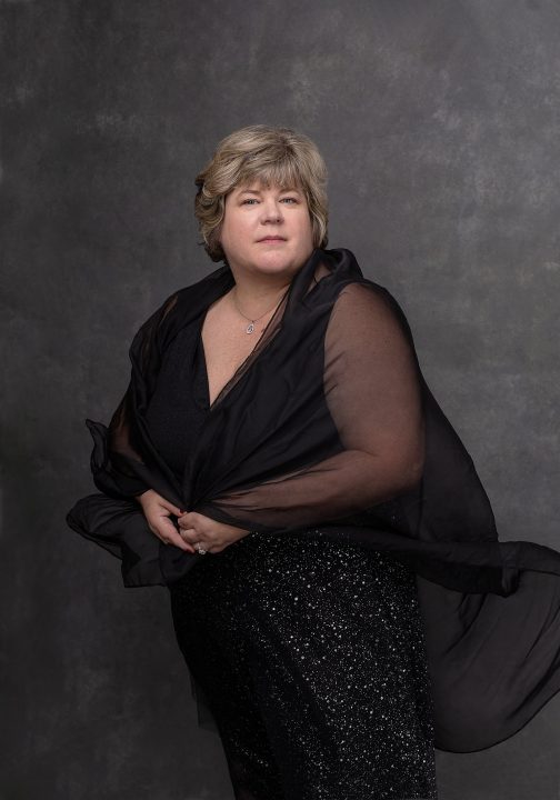 Portrait of Taunya wearing a black dress with sheer scarf for the Over 50 Revolution