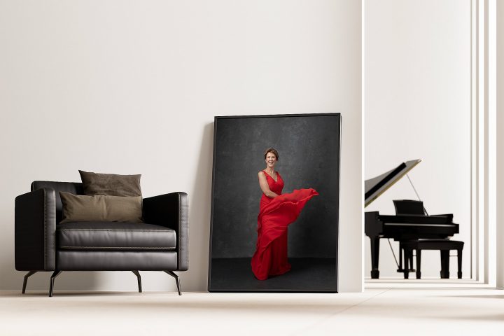 A large framed portrait of Jyl in a red dress