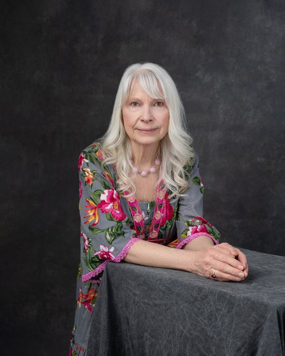 A portrait of Joann, leaning on a table, from her photo session for The Over 50 Revolution at Maundy Mitchell Photography
