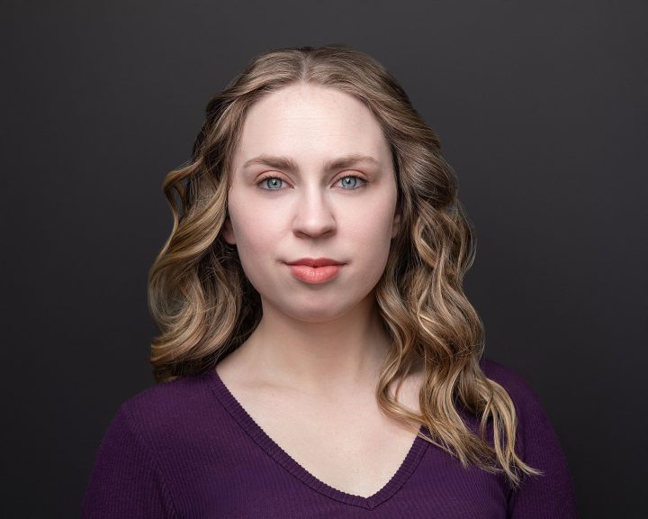 A headshot for Kenzie's five year update - with black background