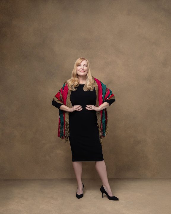 Portrait of Susan wearing a black dress with a confident stance and expression