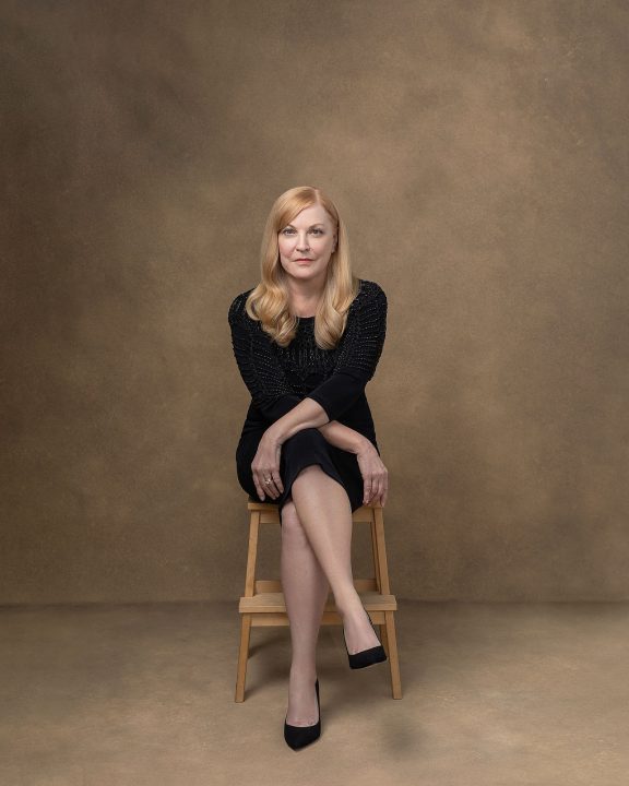 Portrait of Susan seated and wearing a black dress