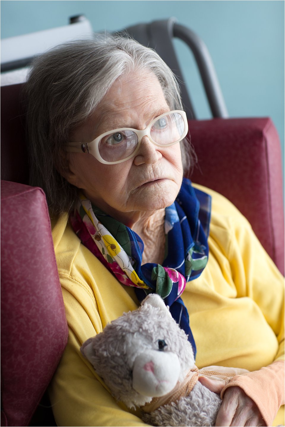 Elderly woman in stylish glasses with stuffed animal (C) Maundy Mitchell