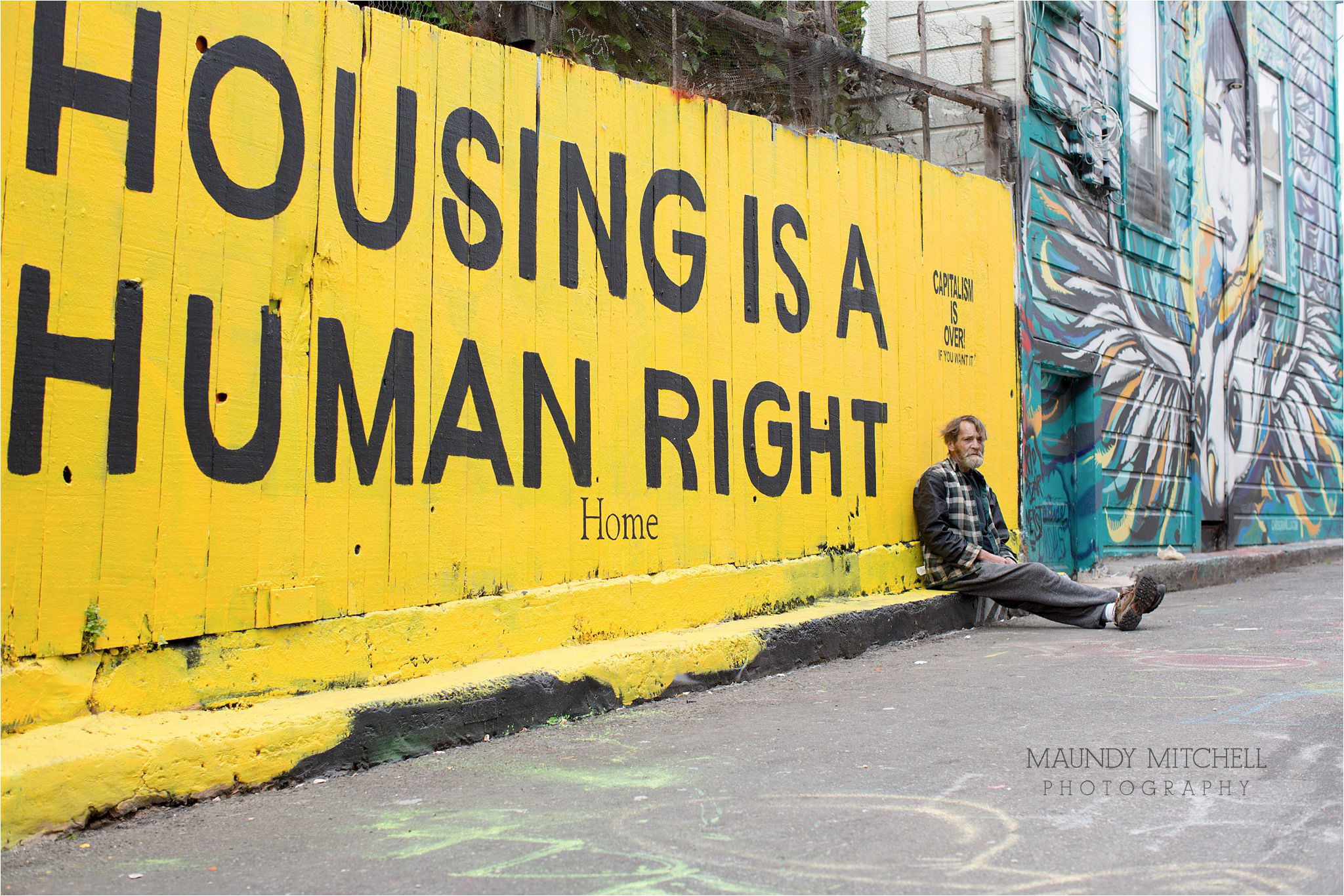 Homeless Man Sitting by Human Rights Mural