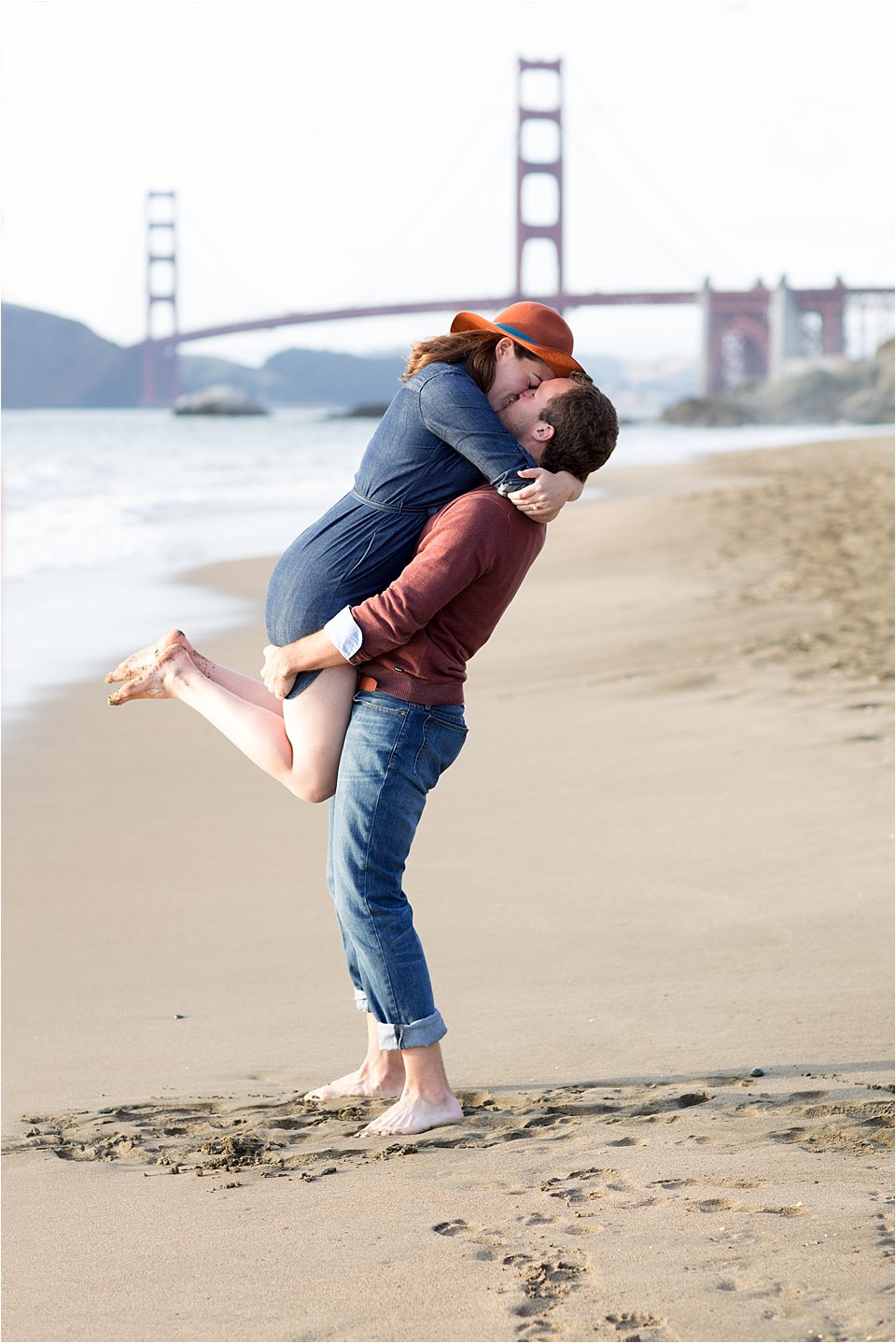 Joyful Engaged Couple on Beach With View of Golden Gate Bridge
