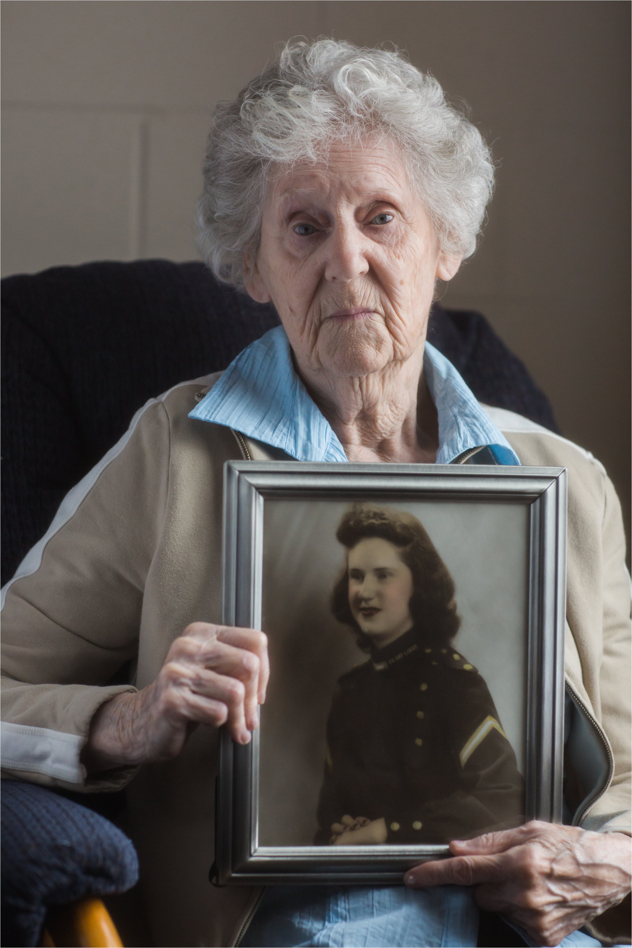 Woman Holding 1940's Military Portrait of Herself