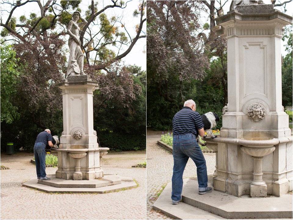 Man Holding Dog to Drinking Fountain (C) Maundy Mitchell