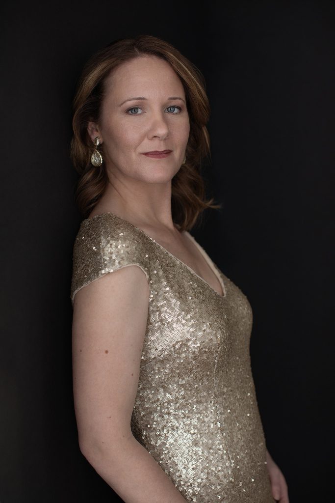 Portrait of Rebecca in a gold gown on a black background