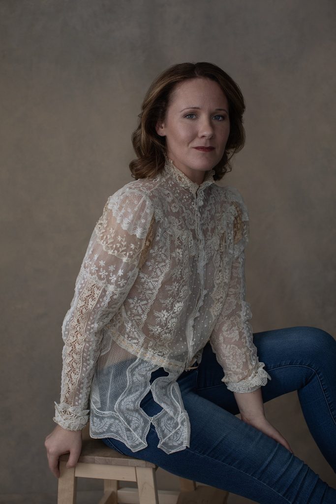 Portrait of Rebecca in antique lace top and jeans.  Neutral tones, Rembrandt lighting, fashion-style pose