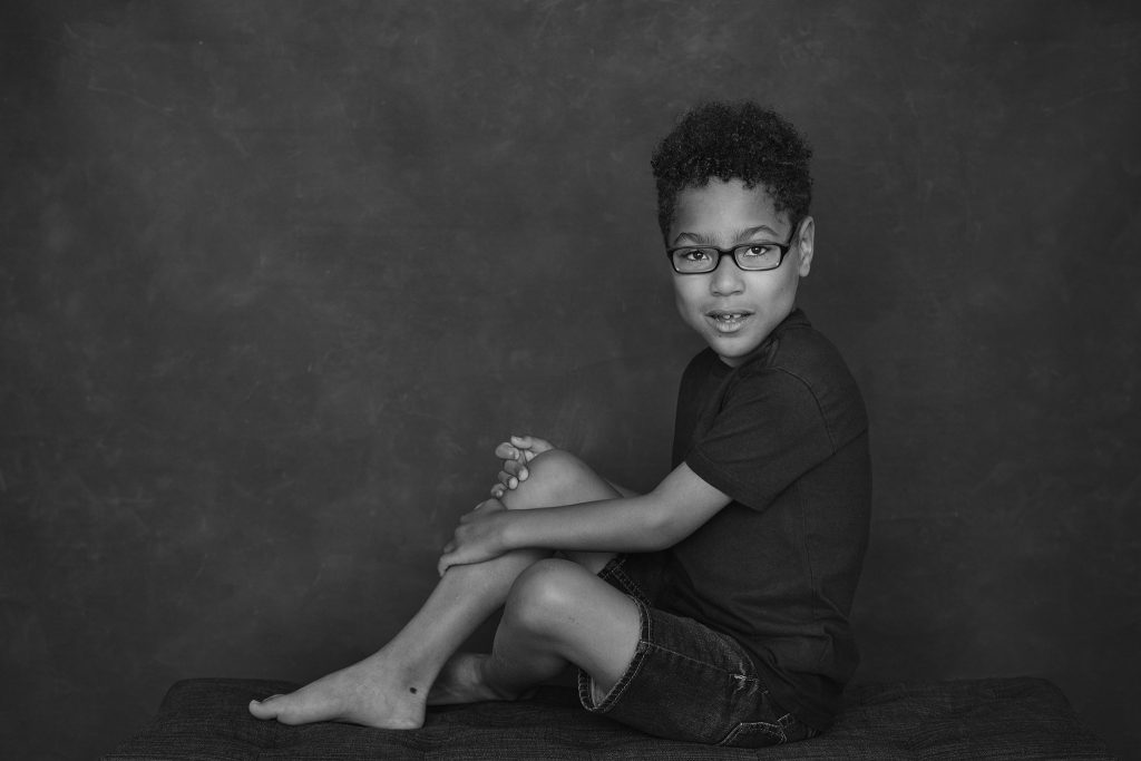 Black and white portrait of Liam seated on a bench