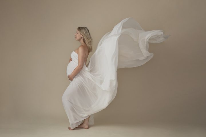Maternity portrait with flowy white silk fabric