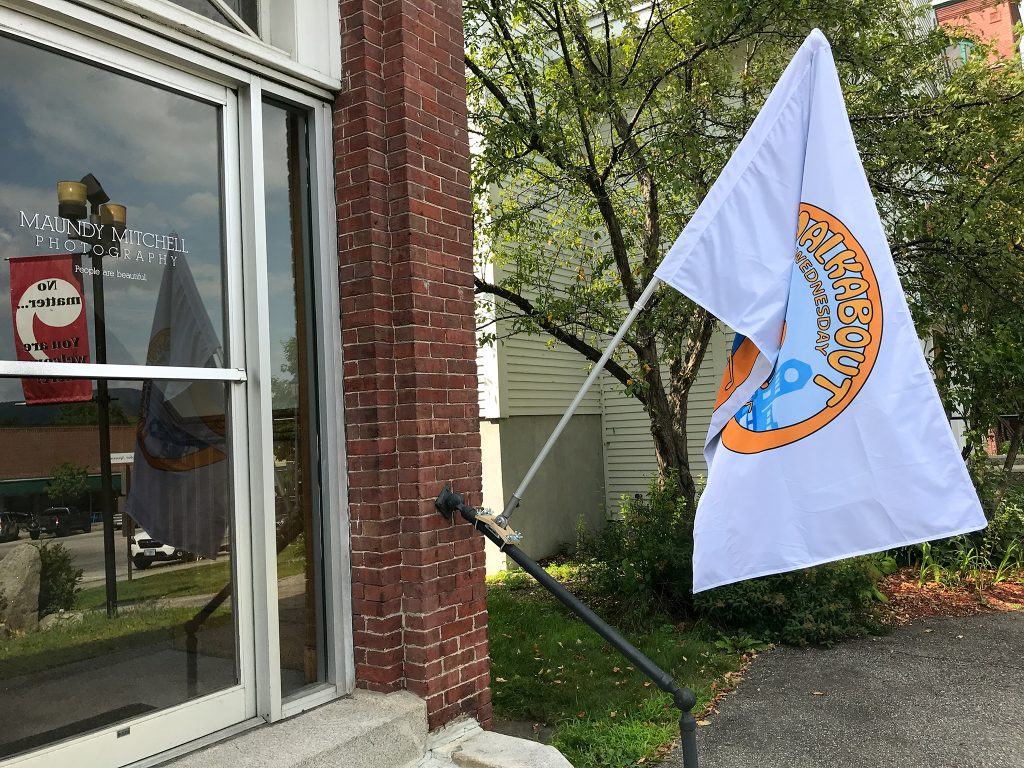 Walkabout Wednesday flag outside Maundy Mitchell Photography studio in downtown Plymouth, New Hampshire