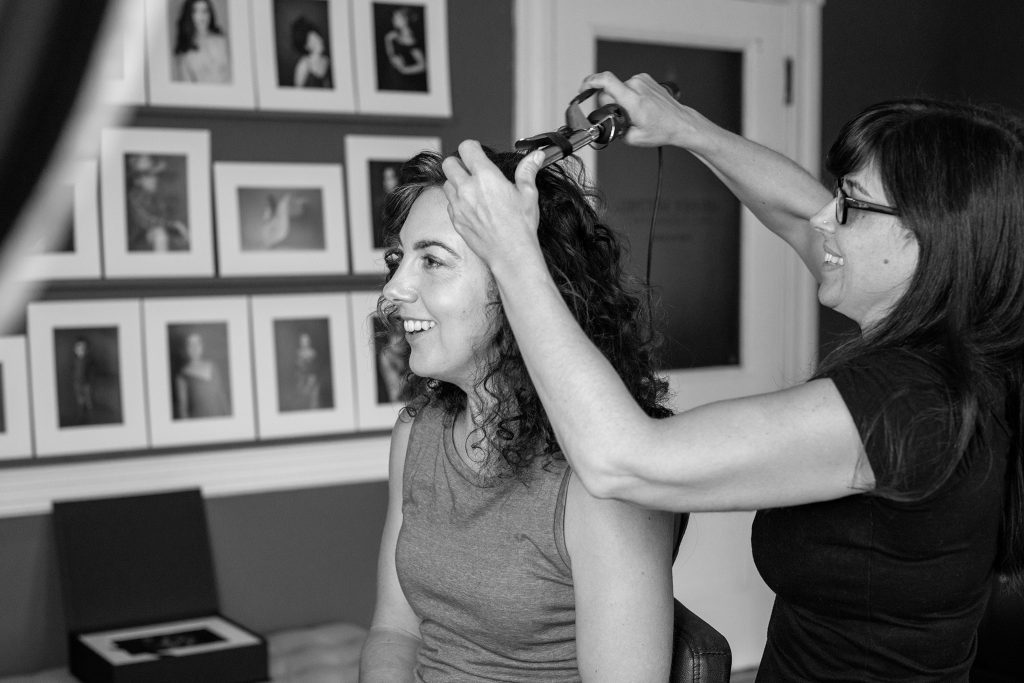 Behind the scenes photo of professional hair and makeup styling before the photo session