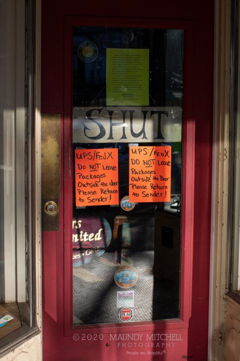 Hand-written signs on the door of a clothing shop