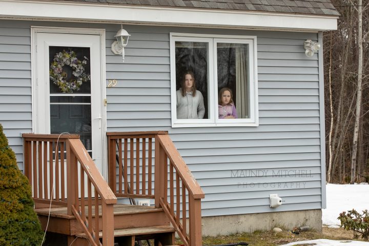 Two sisters look out their window during the pandemic 2020, when remote learning first began.