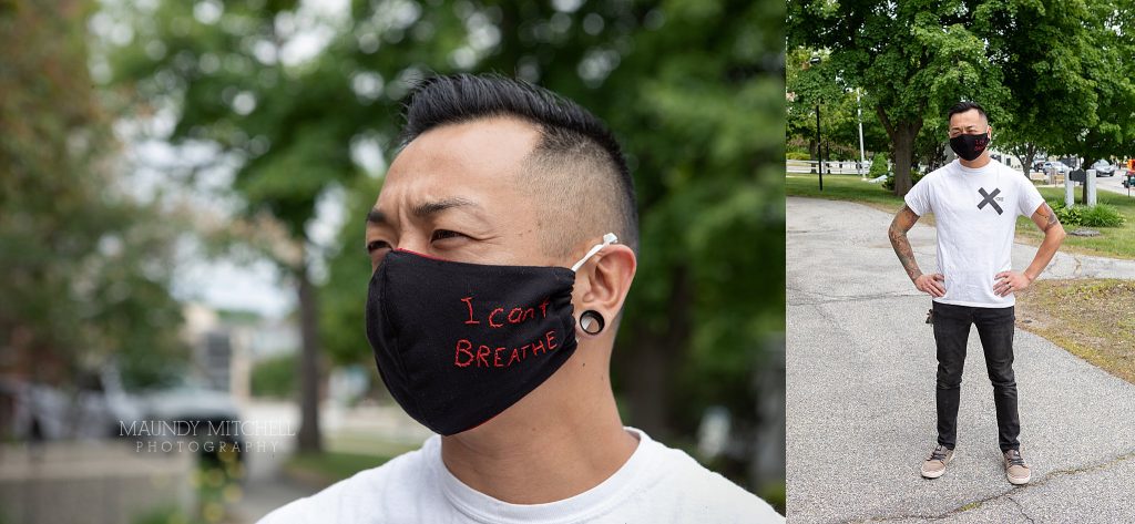 A man on the sidewalk is wearing a mask that reads "I can't breathe"