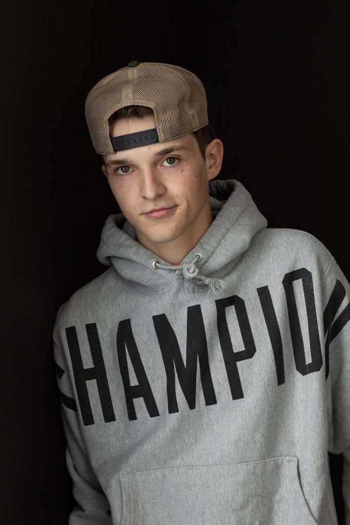 Portrait for a young actor wearing a hoodie and backwards hat
