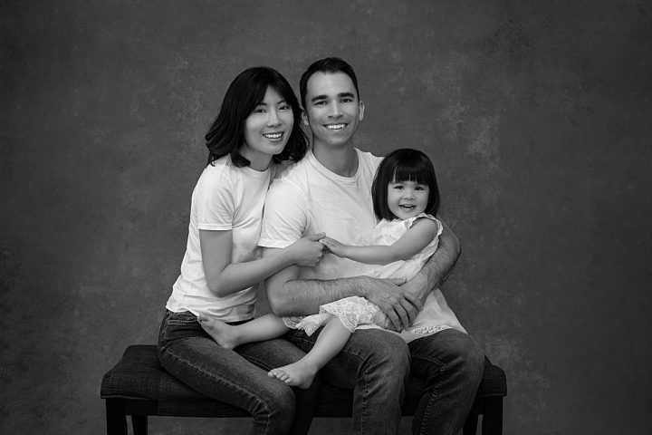 Black and white studio portrait of a family with young daughter in Plymouth, NH.