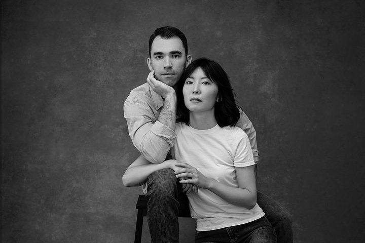 Black and white portrait of piano duo Zi Liang and husband Adam Mayon, wearing casual clothing