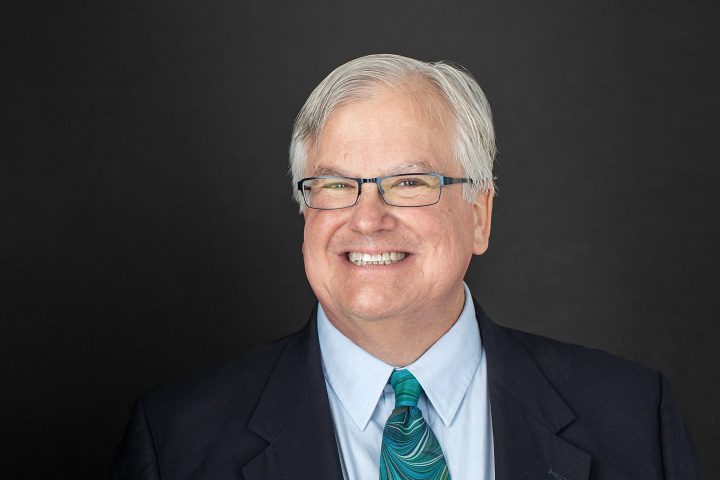 Smiling headshot of musician Jonathan Santore wearing suit coat and tie