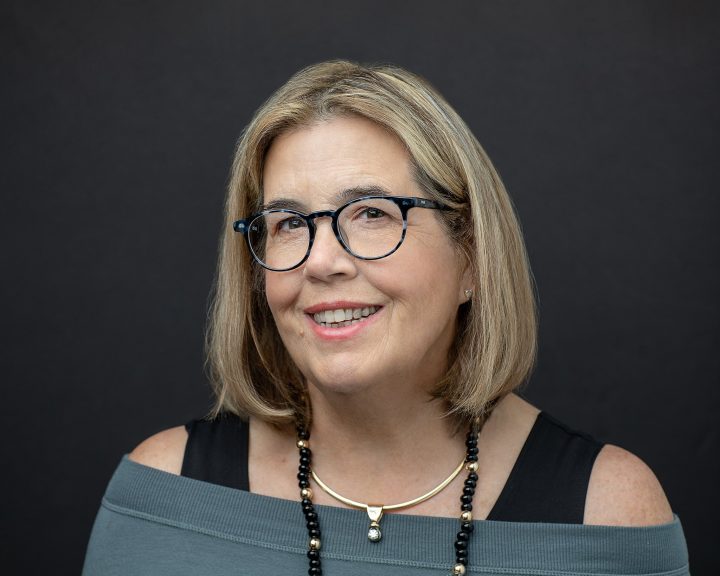 Headshot with dark background for NH artist and author Suzan Gannett