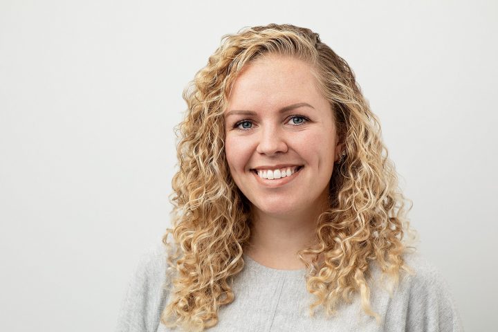 Professional headshot of a smiling woman with a light background