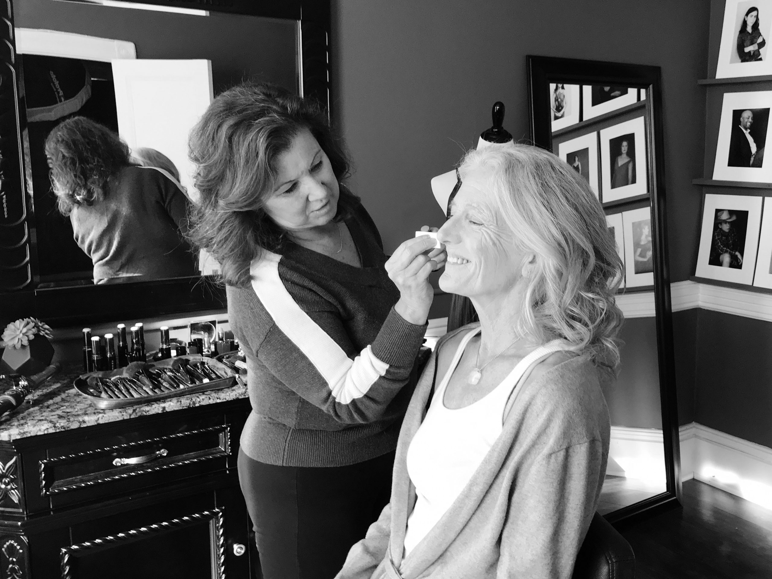 A woman in her 60s enjoying professional hair and makeup styling at the start of her portrait session at Maundy Mitchell Photography
