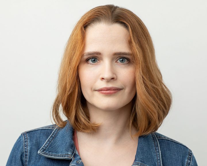 Professional, casual headshot of Rebecca with serious expression on light background