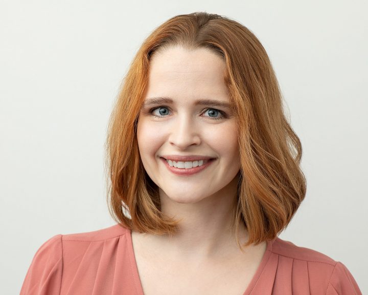 Professional headshot of Rebecca smiling with light background