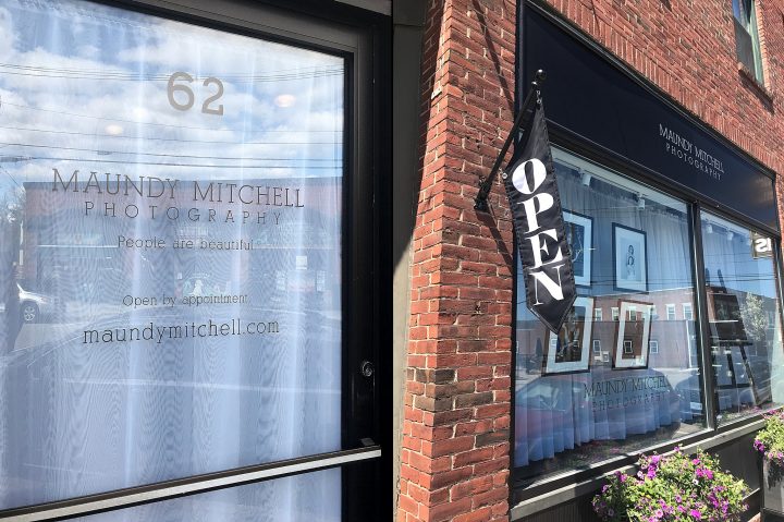 The studio of Maundy Mitchell Photography on Main St., Plymouth, NH - front door and windows with flower boxes and open flag
