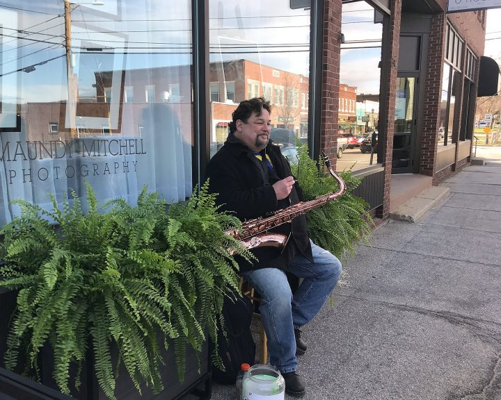 Saxophone player Mark Flynn on the sidewalk outside of Maundy Mitchell Photography studio, Main St. Plymouth, NH