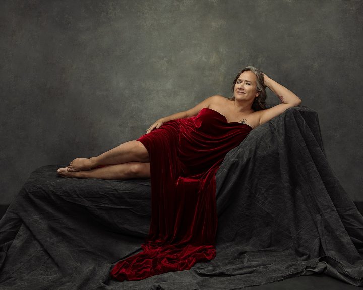 Unforgettable: the Over 50 Revolution, Part II - Mary Francis, reclining and draped in red fabric
