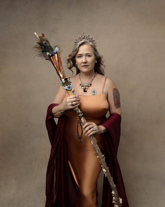 Portrait of a powerful, middle-aged woman wearing gold and holding a scepter