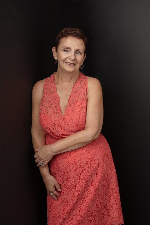 Portrait of a woman wearing a lace coral dress