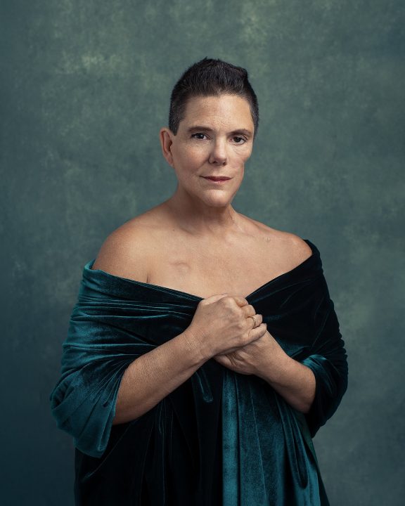 Portrait of a woman over 50, wrapped in teal velvet